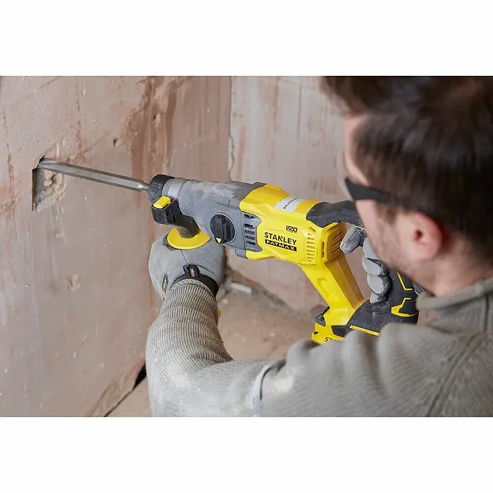 Stanley FatMax Akku-Kombihammer SFMCH900M22-QW - 18 V, 2 Akkus, 4 Ah, 2 J - Aufnahme eines Mannes, der einen Stanley Fatmax Abbruchhammer verwendet, um ein Loch in eine Wand zu bohren.