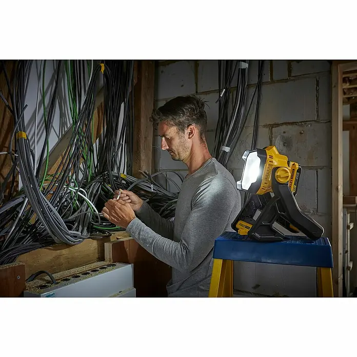 Stanley FatMax LED-Arbeitsleuchte SFMCL030B-XJ - 18 V, Ohne Akku, 1.850 lm - Mann arbeitet an Kabeln mit der Stanley FATMAX Akku-Arbeitsleuchte, die helles Licht spendet.