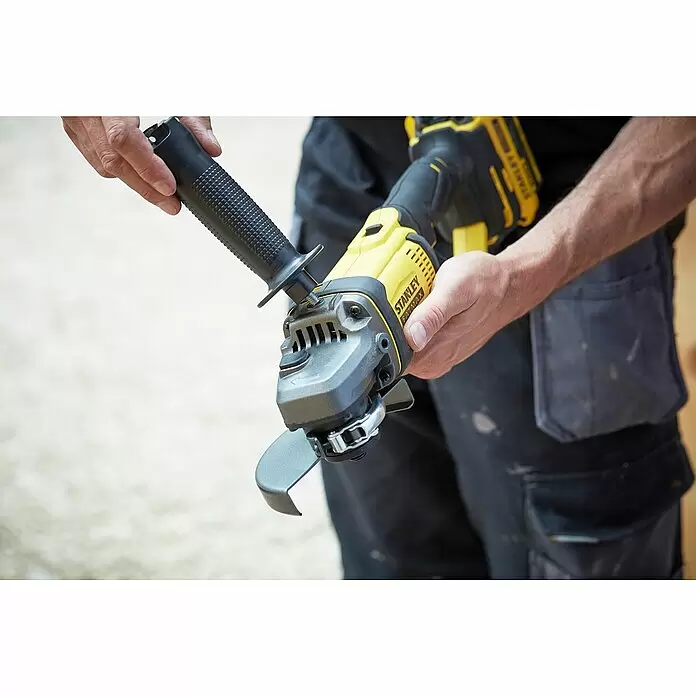 Stanley FatMax Akku-Winkelschleifer SFMCG400M2K-QW - 2 Akkus, 4 Ah, Durchmesser Scheibe: 125 mm, 9.000 U/min - Eine Person hält einen gelb-schwarzen Stanley FatMax Winkelschleifer. Er hat einen schwarzen texturierten Griff und eine Schutzhaube.