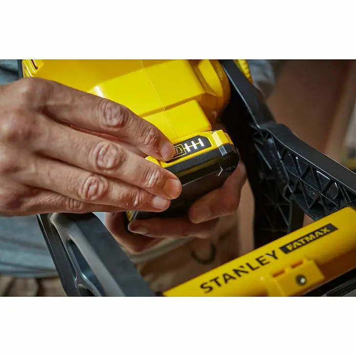 Stanley FatMax LED-Arbeitsleuchte SFMCL030B-XJ - 18 V, Ohne Akku, 1.850 lm - Nahaufnahme eines Stanley Fatmax Werkzeugs mit Akku in gelber Farbe, das von Händen gehalten wird.