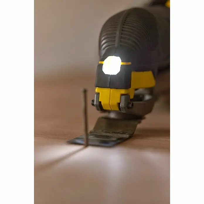 Stanley FatMax Akku-Multifunktionswerkzeug SFMCE500B-XJ - 18 V, Ohne Akku - Nahaufnahme einer Stichsäge der Marke Stanley, die auf einer Holzoberfläche arbeitet und von einer eingebauten LED beleuchtet wird.