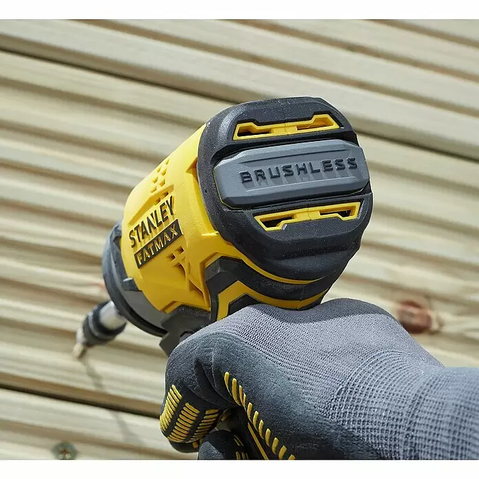 Stanley FatMax Akku-Schlagschrauber SFMCF810D2K-QW - 18 V, 2 Akkus, 2 Ah, 170 Nm - Eine Person in grauem Handschuh hält einen gelb-schwarzen Stanley FatMax Brushless Schlagschrauber, der eine Schraube in Holzbretter treibt.