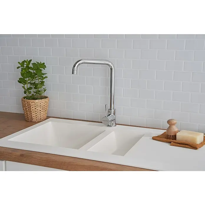 Respekta Einbauspüle Denver - 50 x 100 cm, Anzahl Becken: 1,5 Stk., Weiß - Nahaufnahme eines modernen Waschbeckens mit Armatur, ergänzt durch eine Pflanze und natürliche Seife, vor einer weißen Backsteinwand.
