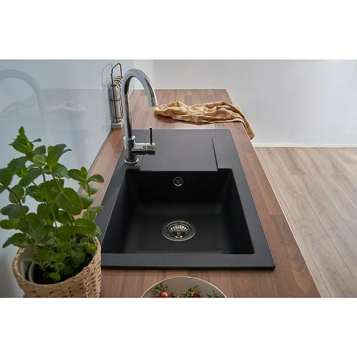 Respekta Einbauspüle Denver - 78 x 43,5 cm, Schwarz - Eine moderne schwarze Spüle mit Abtropffläche und einem eleganten Chromhahn, umgeben von einer Holzarbeitsplatte und frischen Kräutern.