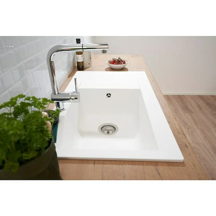 Respekta Einbauspüle Denver - 86 x 50 cm, Weiß, Anzahl Becken: 1 Stk. - Nahaufnahme einer modernen, weißen Küchenspüle mit einem verchromten Wasserhahn auf einer hölzernen Arbeitsplatte, neben einem Topf mit frischen Kräutern.