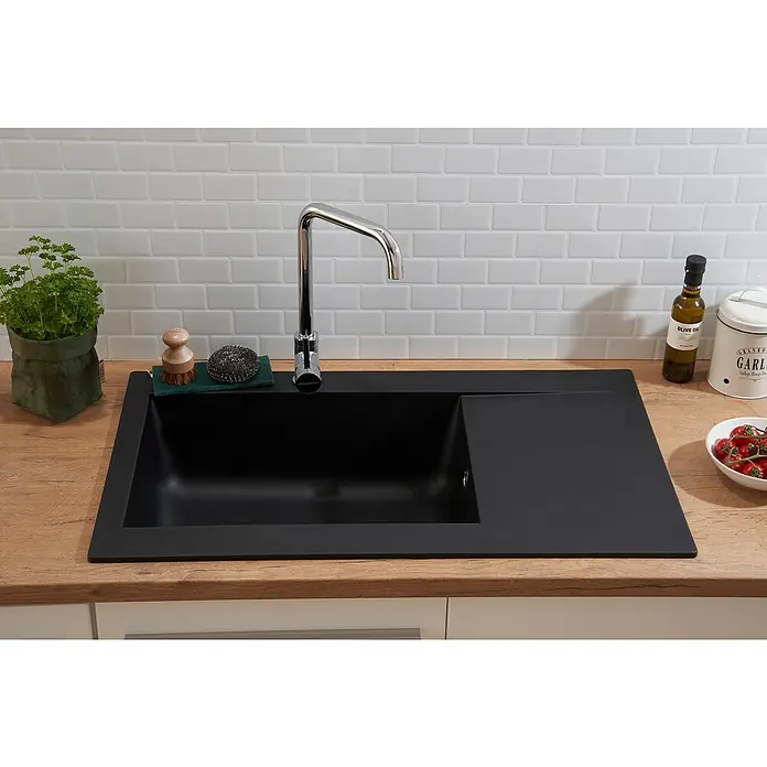 Respekta Einbauspüle Denver - 86 x 50 cm, Schwarz, Anzahl Becken: 1 Stk. - Elegantes schwarzes Spülbecken mit Abtropffläche, Armatur und Küchenutensilien auf einer Holzarbeitsplatte vor weißem Fliesenspiegel.