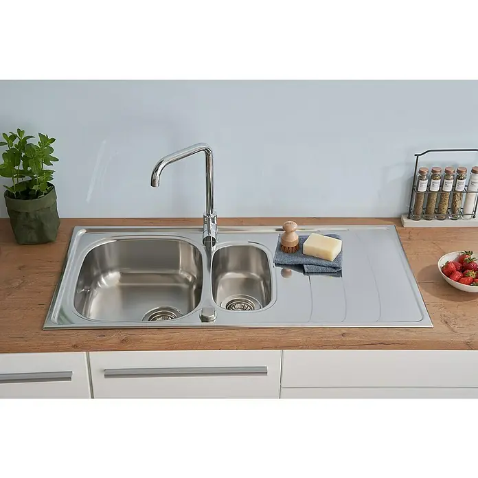 Respekta Einbauspüle Miami - 100 x 50 cm, Edelstahl - Edelstahlspüle mit Abtropffläche, Armatur, Bürste, Seife, Geschirrtuch, Gewürze und Erdbeeren auf einer hölzernen Arbeitsplatte in einer Küche.