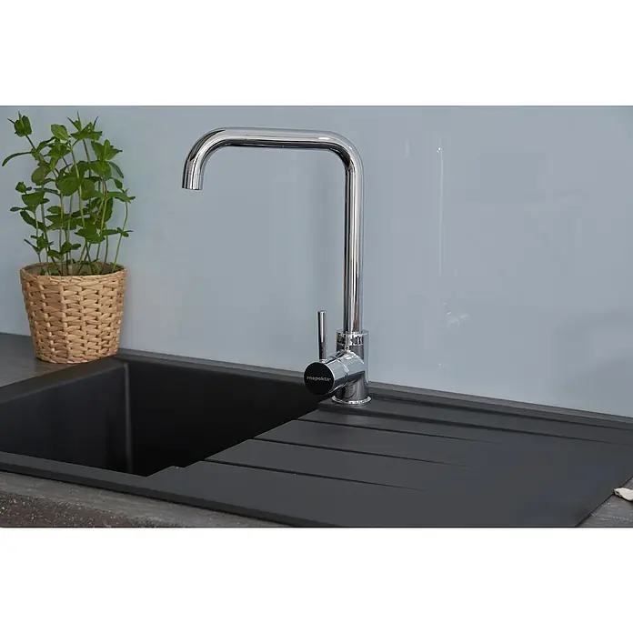 Respekta Einbauspüle Houston - 80 x 50 cm, Schwarz, Anzahl Becken: 1 Stk. - Eine moderne Küchenspüle mit Armatur und einem Topf mit grünen Pflanzen. Die Spüle ist schwarz und die Armatur ist aus Chrom.
