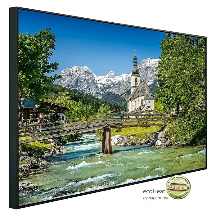Papermoon Infrarot-Bildheizkörper Bayerische Alpen - 120 x 60 cm, 1.000 W - Ein gerahmtes Leinwandbild mit einer malerischen Ansicht der St. Sebastian Kirche in Ramsau vor einer beeindruckenden Bergkulisse.