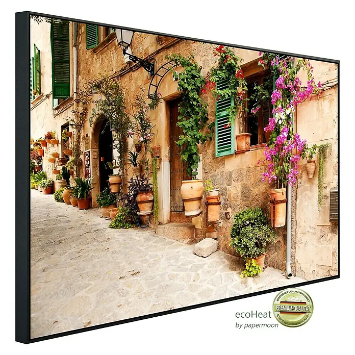 Papermoon Infrarot-Bildheizkörper Valdemossa Mallorca - 100 x 60 cm, 800 W - Ein gerahmtes Wandbild, das eine malerische Gasse mit blühenden Pflanzen und rustikalen Gebäuden zeigt, ideal für eine stimmungsvolle Dekoration.