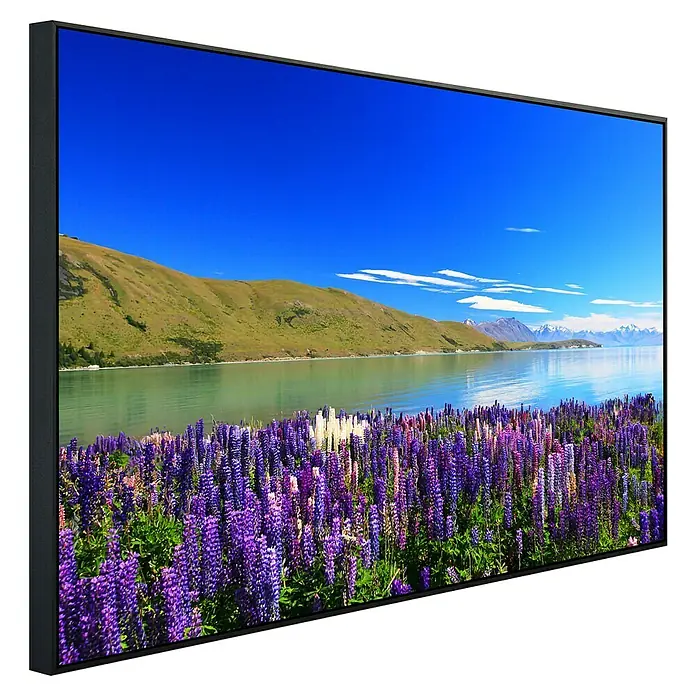 Papermoon Infrarot-Bildheizkörper Lupinen See Tekapo - 100 x 60 cm, 600 W - Ein moderner TV mit atemberaubendem Landschaftsbild. Der Rahmen ist schlank, das Display zeigt See, Berge & Blumen in lebendigen Farben.