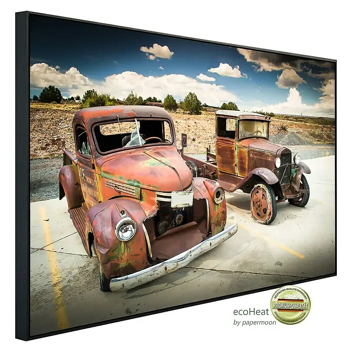 Papermoon Infrarot-Bildheizkörper Verlassene alte Autos - 90 x 50 cm, 450 W - Das Bild zeigt ein gerahmtes Kunstwerk mit zwei Oldtimer-LKWs vor einer Landschaftskulisse, das eine nostalgische Atmosphäre vermittelt.