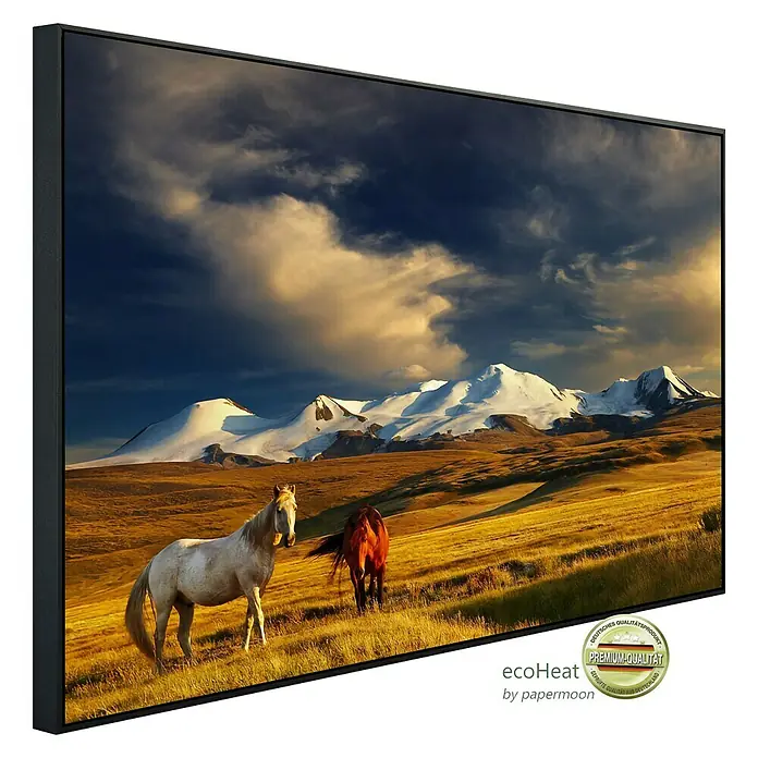 Papermoon Infrarot-Bildheizkörper Weidende Pferde - 100 x 60 cm, 600 W - Ein gerahmtes Bild mit einer weissen und einer braunen Pferd vor einer Bergkulisse. Das Bild verleiht jedem Raum eine ruhige und natürliche Atmosphäre.