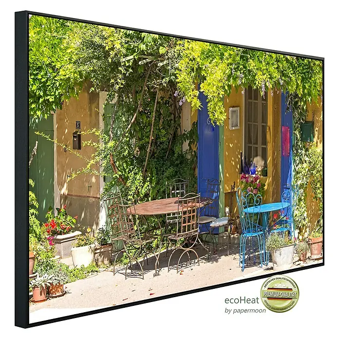 Papermoon Infrarot-Bildheizkörper Provence Cafe Shop - 100 x 60 cm, 800 W - Ein gerahmtes Wandbild mit einer idyllischen Straßenszene mit Tischen und Stühlen vor farbenfrohen Häusern.