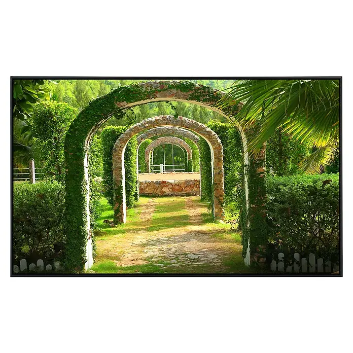 Papermoon Infrarot-Bildheizkörper Pergola Garten - 60 cm x 500 mm, 350 W - Ein bezaubernder Gartenweg, gesäumt von Bögen mit üppigem Grün und Steinelementen, die eine friedliche und einladende Atmosphäre schaffen.