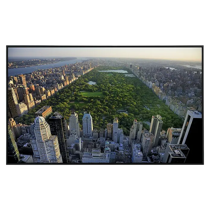 Papermoon Infrarot-Bildheizkörper Blick auf den Central Park - 120 cm x 600 mm, 1.000 W - Luftaufnahme des Central Park in New York, umrahmt von Wolkenkratzern, in einem modernen schwarzen Rahmen, der das Bild hervorhebt.