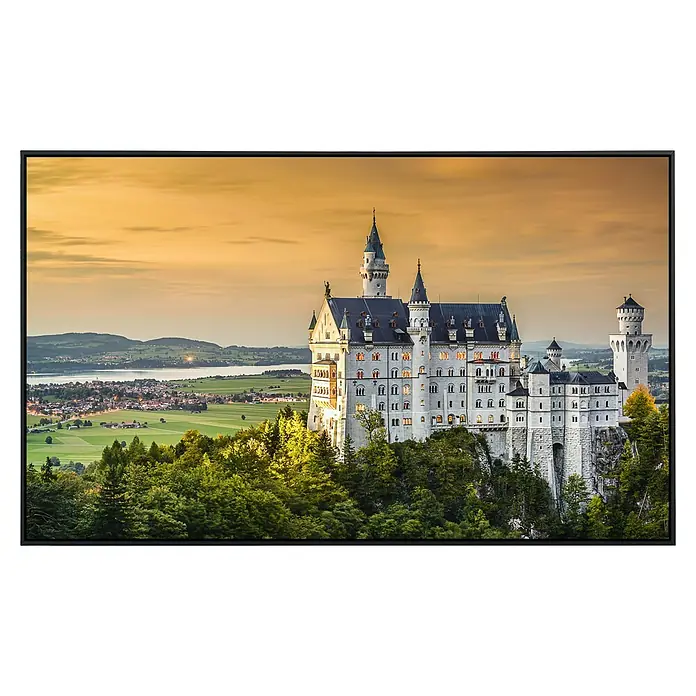 Papermoon Infrarot-Bildheizkörper Schloss Neuschwanstein - 90 cm x 500 mm, 450 W - Märchenschloss Neuschwanstein thront erhaben über grünen Hügeln, ein Sinnbild deutscher Romantik unter einem goldenen Abendhimmel.