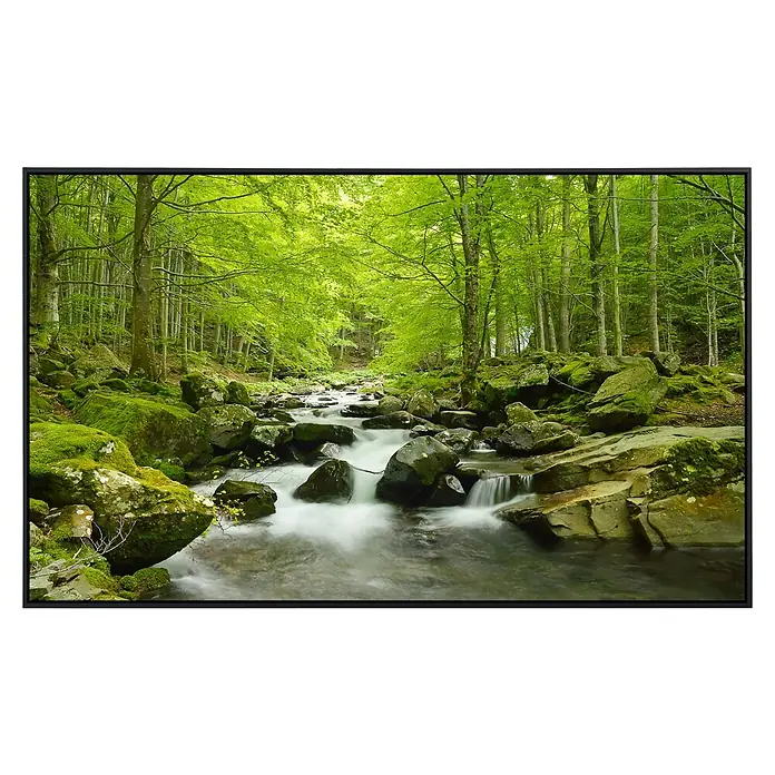 Papermoon Infrarot-Bildheizkörper Weicher Wasserstrom - 120 x 60 cm, 1.000 W - Grüner Wald mit Bachlauf als gerahmtes Wandbild. Das Bild zeigt einen üppigen Wald mit fließendem Bach und moosbedeckten Steinen.