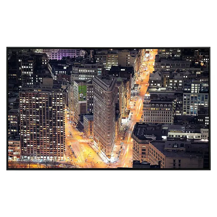 Papermoon Infrarot-Bildheizkörper Flat Iron Building - 120 cm x 600 mm, 1.000 W - Das Foto zeigt eine Nachtansicht des Flatiron Buildings in New York City. Das Gebäude ist von beleuchteten Straßen und anderen Wolkenkratzern umgeben.