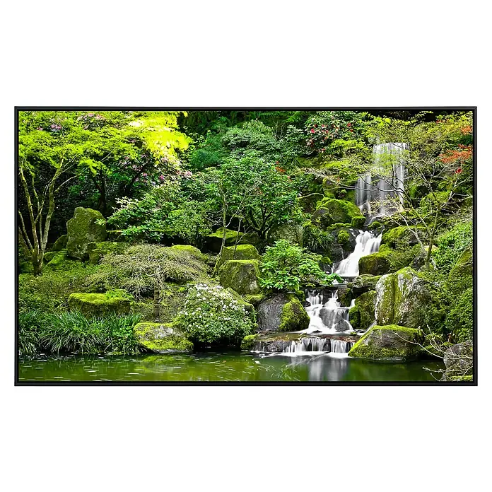Papermoon Infrarot-Bildheizkörper Gartenteich - 90 x 50 cm, 450 W - Ein malerischer Wasserfall mit grünen Moosfelsen und üppiger Vegetation, eingefasst in einem schwarzen Rahmen.
