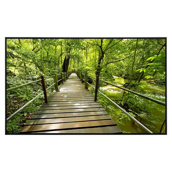 Papermoon Infrarot-Bildheizkörper Bridge Walk - 60 x 50 cm, 350 W - Eine lange Holzbrücke mit Geländern führt durch einen dichten, grünen Wald und überquert einen kleinen Fluss. Ruhige und naturverbundene Atmosphäre.