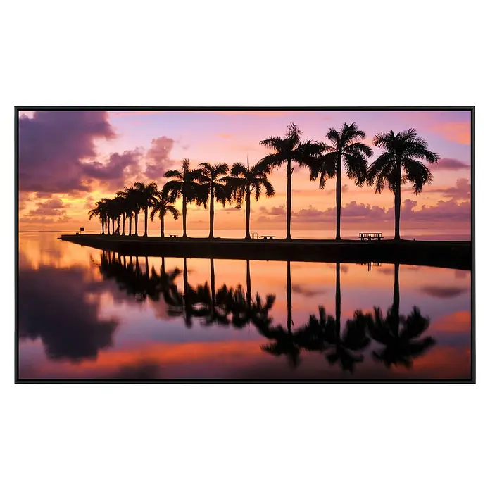Papermoon Infrarot-Bildheizkörper Schönheit und Strand - 90 x 50 cm, 450 W - Das Bild zeigt eine Leinwand mit Palmen bei Sonnenuntergang, die sich im Wasser spiegeln und eine friedliche, tropische Atmosphäre erzeugen.