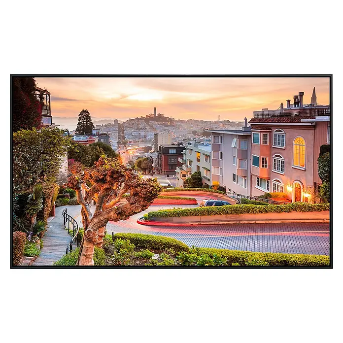 Papermoon Infrarot-Bildheizkörper Lombard Street in San Francisco - 60 x 50 cm, 350 W - Wiedergabe einer Landschaftsansicht auf einem modernen Fernseher mit schlankem, schwarzem Rahmen. Das Display zeigt eine Stadtansicht mit einer kurvenreichen Straße.