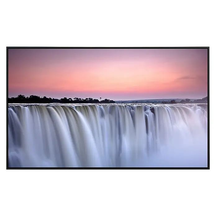 Papermoon Infrarot-Bildheizkörper die Victoriafälle - 120 cm x 600 mm, 1.200 W - Das Bild zeigt einen Fernseher, der ein atemberaubendes Foto der Victoriafälle bei Sonnenuntergang anzeigt. Die Farben des Himmels spiegeln sich im Wasserfall.