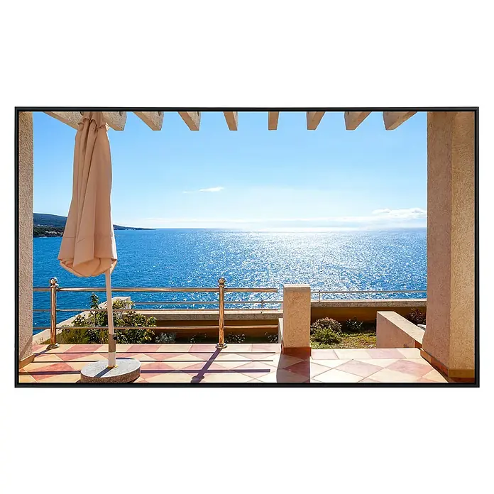 Papermoon Infrarot-Bildheizkörper Terrasse mit Meerblick - 60 cm x 500 mm, 350 W - Blick von einer Terrasse mit Sonnenschirm auf das glitzernde Meer an einem sonnigen Tag.