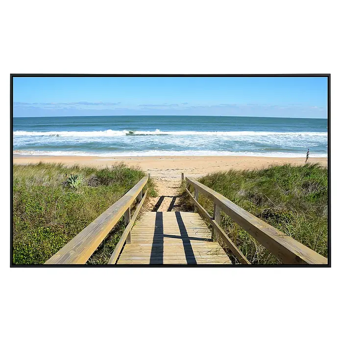 Papermoon Infrarot-Bildheizkörper Dunes St Augustine - 90 x 50 cm, 450 W - Ein hölzerner Strandweg führt zum Sandstrand mit Wellen unter einem klaren, blauen Himmel.