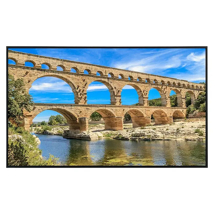 Papermoon Infrarot-Bildheizkörper Pont du Gard Aquädukt - 60 x 50 cm, 350 W - Das Pont du Gard Aquädukt, ein beeindruckendes römisches Bauwerk, das sich über den Fluss schlängelt, mit strahlend blauem Himmel im Hintergrund.