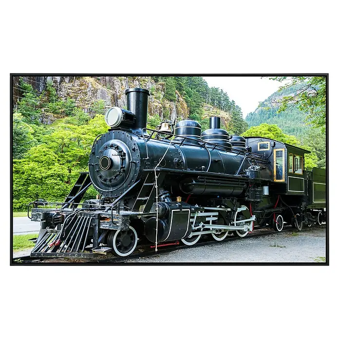 Papermoon Infrarot-Bildheizkörper Alte Dampflokomotive - 100 x 60 cm, 600 W - Nahaufnahme einer schwarzen Dampflokomotive vor einer grünen Hügellandschaft. Die Lokomotive ist detailreich und gut erhalten.