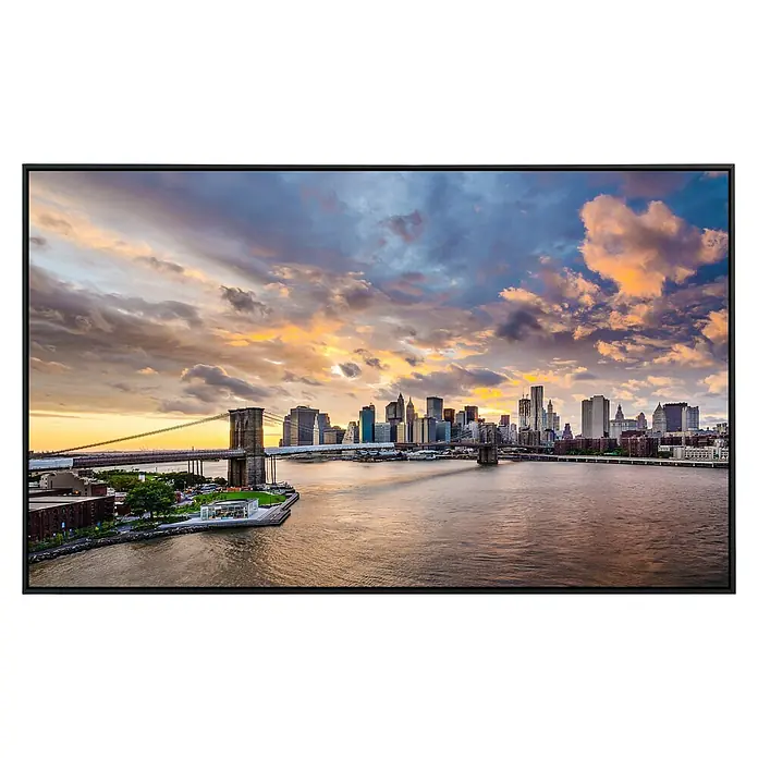 Papermoon Infrarot-Bildheizkörper Brooklyn Brücke - 100 x 60 cm, 600 W - Das Bild zeigt die Brooklyn Bridge und die Skyline von New York bei Sonnenuntergang, gerahmt in einem eleganten schwarzen Rahmen.