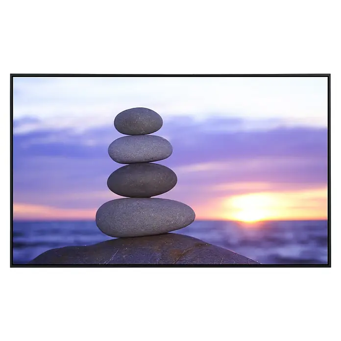 Papermoon Infrarot-Bildheizkörper Zen Sonnenuntergang - 100 x 60 cm, 800 W - Ein Turm aus balancierenden Steinen, der Ruhe und Ausgeglichenheit ausstrahlt, vor einem friedlichen Sonnenuntergang.