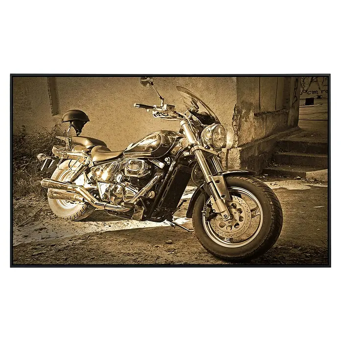 Papermoon Infrarot-Bildheizkörper Vintage Motorrad - 100 x 60 cm, 600 W - Aufnahme eines klassischen Motorrads in Sepiatönen mit elegantem Design und einem Helm auf dem Sitz, das vor einem urbanen Hintergrund steht.