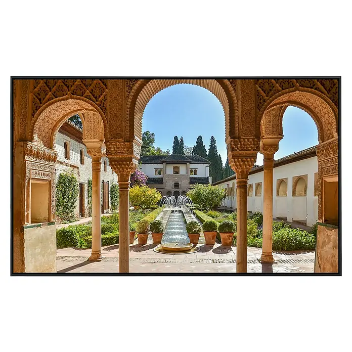 Papermoon Infrarot-Bildheizkörper Generalife Garten - 100 x 60 cm, 600 W - Ein malerischer Blick durch kunstvolle Bögen auf den üppigen Garten des Alhambra Palastes in Granada, Spanien.