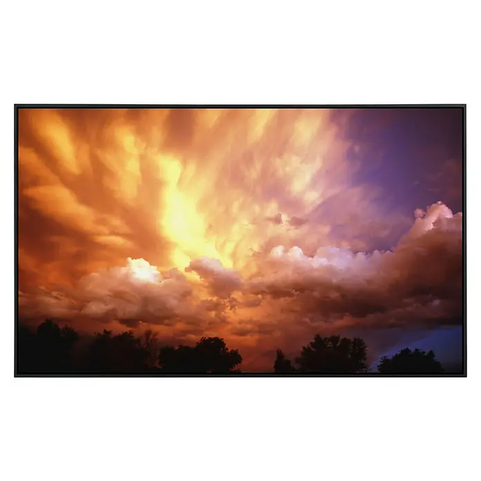 Papermoon Infrarot-Bildheizkörper Gewitterwolken bei Sonnenuntergang - 100 x 60 cm, 800 W - Leinwanddruck mit dramatischer Himmelslandschaft bei Sonnenuntergang, intensive Farben von Orange bis Violett, Bäume im Vordergrund.