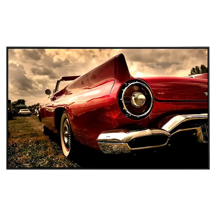 Papermoon Infrarot-Bildheizkörper Sepia Oldtimer 1 - 120 x 60 cm, 1.000 W - Detailaufnahme eines roten Oldtimer-Cabrios mit Chromstoßstange und markantem Rücklicht. Der Lack glänzt unter dem bewölkten Himmel.