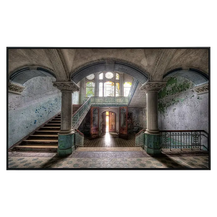 Papermoon Infrarot-Bildheizkörper Lost Space Beelitz - 1.000 x 600 mm, 800 W - Eindrucksvolles Foto eines verlassenen Gebäudes mit verfallender Architektur und einer offenen Tür, die Licht hereinlässt.