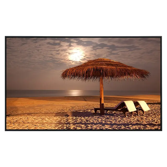 Papermoon Infrarot-Bildheizkörper Sunset Beach - 1.000 x 600 mm, 600 W - Malerisches Foto eines Strandbildes mit Sonnenschirm und Liegen im Abendlicht, gerahmt in einem eleganten schwarzen Rahmen.