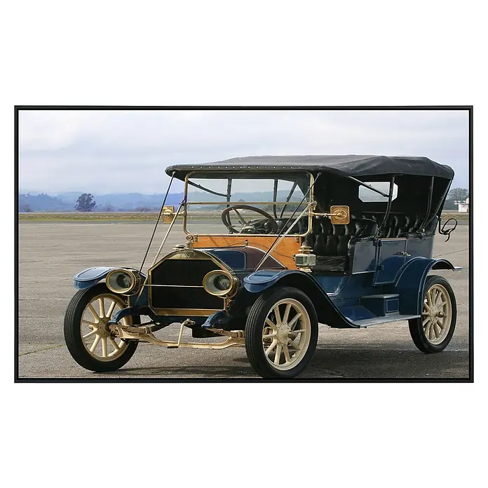 Papermoon Infrarot-Bildheizkörper Klassisches Auto - 60 x 50 cm, 350 W - Detailaufnahme eines blauen Oldtimers mit goldenen Akzenten, der auf einem Flugplatz steht. Die elegante Silhouette und die klassischen Details sind auffällig.