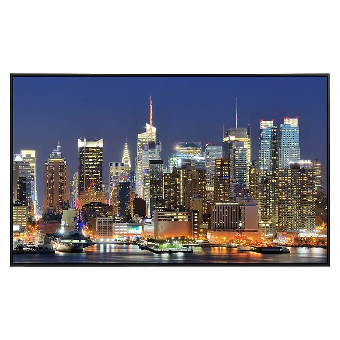 Papermoon Infrarot-Bildheizkörper Manhattan Skyline 2 - 60 x 50 cm, 350 W - Schwarzer TV-Rahmen mit Blick auf die glitzernde Skyline von New York City bei Nacht.