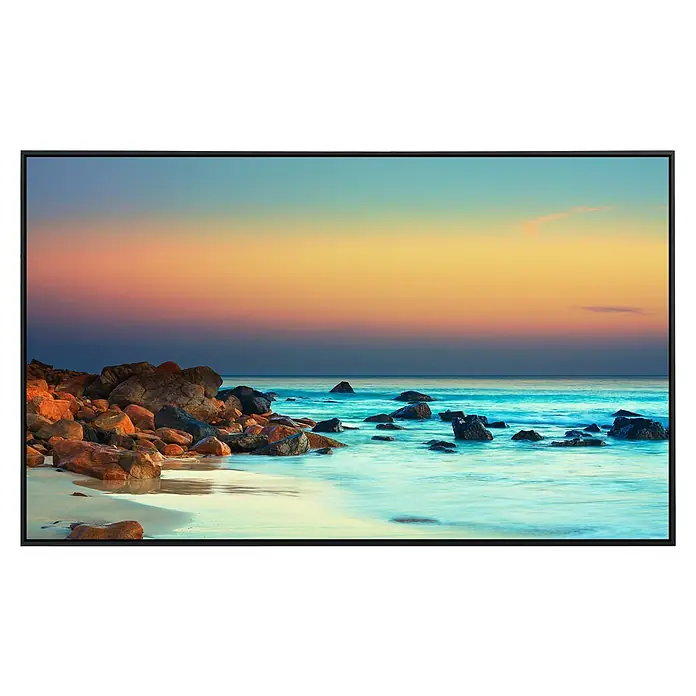 Papermoon Infrarot-Bildheizkörper Sonnenuntergang über dem Meer - 100 x 60 cm, 600 W - Das Bild zeigt ein modernes Display, das ein friedliches Strandmotiv mit Felsen im ruhigen Wasser bei Sonnenuntergang darstellt.