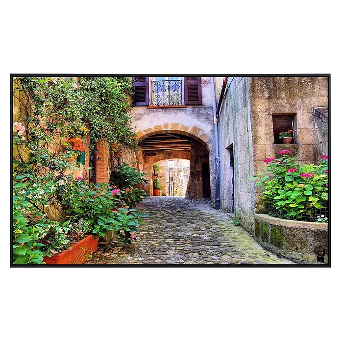 Papermoon Infrarot-Bildheizkörper Altes toskanisches Dorf - 100 x 60 cm, 600 W - Ein malerischer Blick auf eine Gasse mit einem Bogengang, üppiger Vegetation und charmanten architektonischen Details.