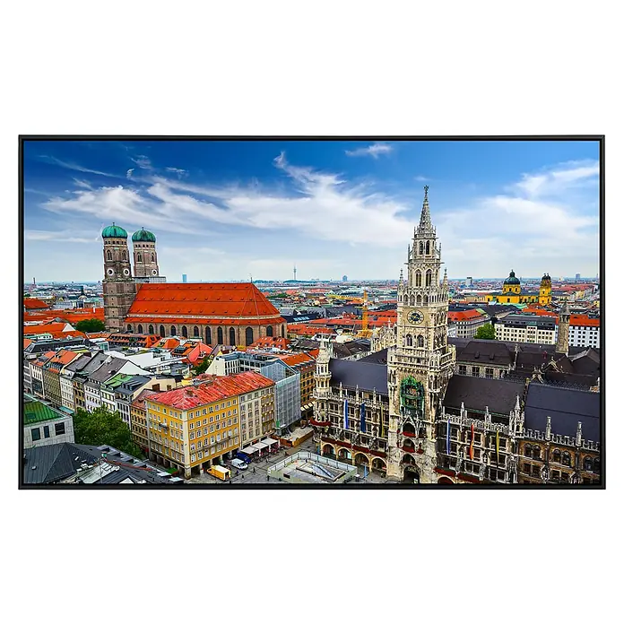 Papermoon Infrarot-Bildheizkörper Münchner Skyline - 60 x 50 cm, 350 W - Luftaufnahme von München mit Fokus auf Rathaus und Frauenkirche, eingebettet in eine malerische Stadtansicht mit blauem Himmel.