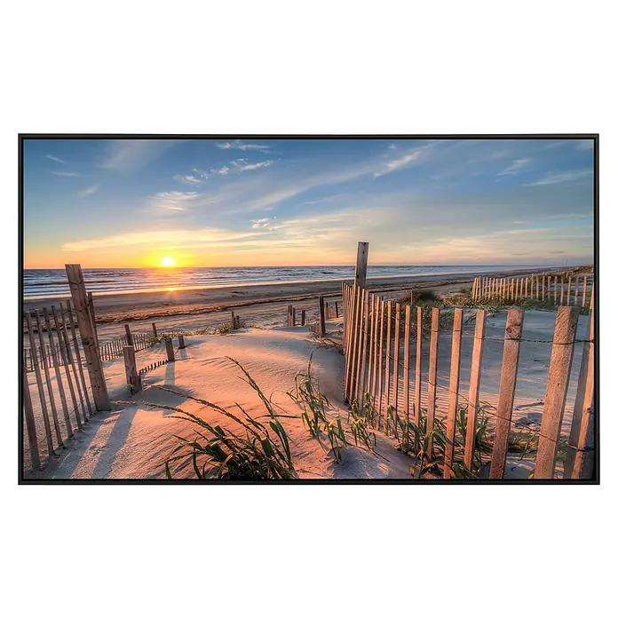 Papermoon Infrarot-Bildheizkörper Outer Banks Dunes - 100 x 60 cm, 600 W - Das Foto zeigt eine Leinwand mit einem malerischen Strand bei Sonnenuntergang, umgeben von einem eleganten schwarzen Rahmen.