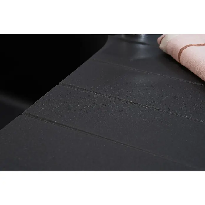 Respekta Einbauspüle Orlando - 100 x 50 cm, Schwarz - Detailaufnahme einer dunklen Spüle mit Abtropffläche, daneben ein Tuch. Die Spüle präsentiert sich mit einer strukturierten Oberfläche.