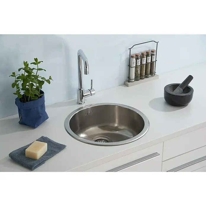 Respekta Fregadero encastrable Portland - Diámetro: 44,6 cm, Acero inoxidable - Fregadero encastrado de acero inoxidable con grifo, hierbas aromáticas y jabón sobre una encimera blanca.