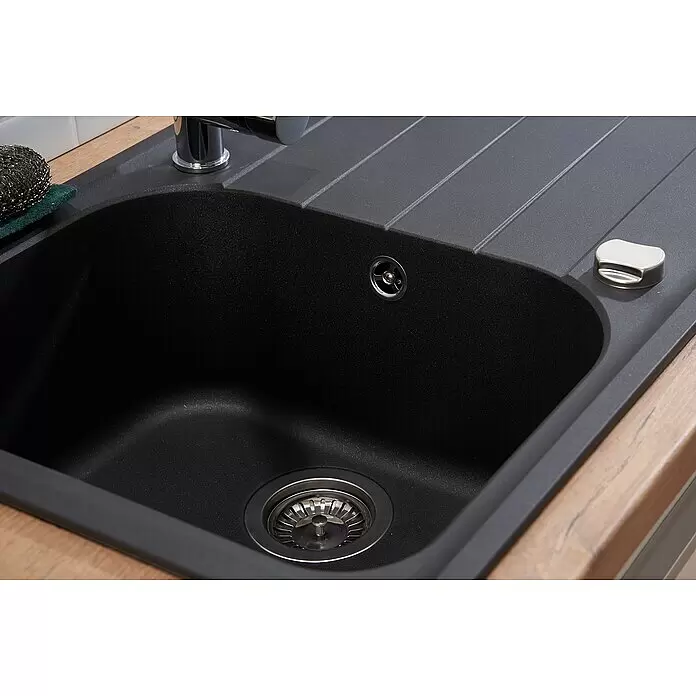 Respekta Fregadero encastrable Orlndo - 86 x 50 cm, Negro - Primer plano de un fregadero de granito negro con escurridor integrado, grifo cromado, desagüe principal, rebosadero y botón dispensador de jabón.