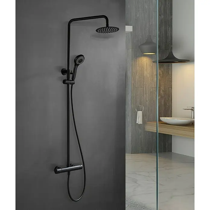 Imex Sistema de ducha Kent - Con grifo termostático, Negro - La imagen presenta un moderno sistema de ducha en negro mate con rociador fijo y ducha de mano, montado en una pared gris, que ofrece una experiencia elegante.